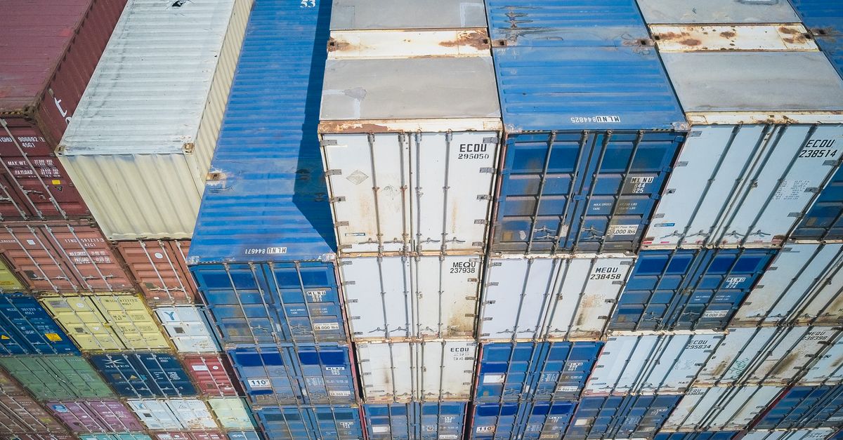 Aerial view showing colorful stacked cargo containers at a shipping yard.